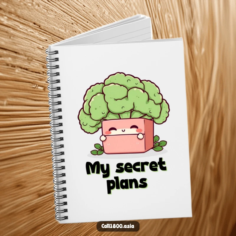 Funny bento box character winking from behind a broccoli floret on the cover of a ruled notebook.
